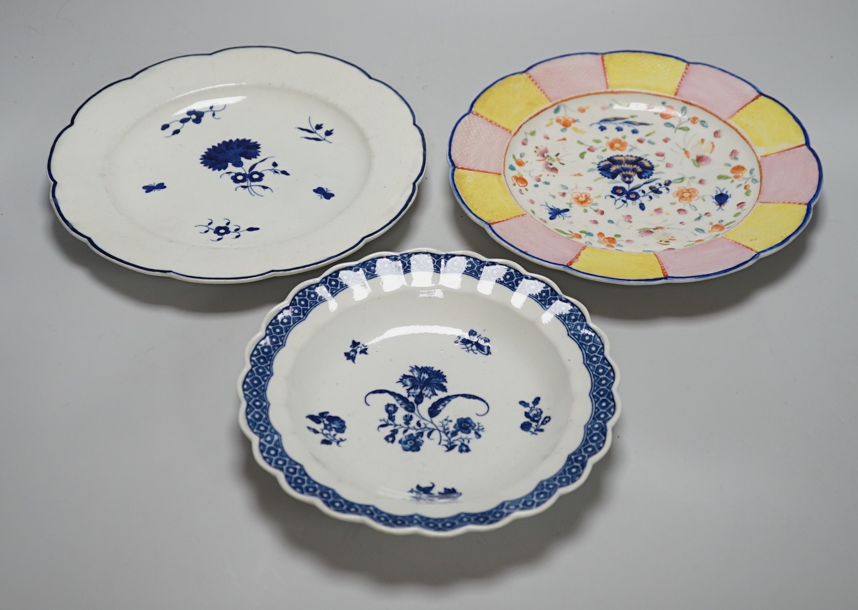 An 18th century Caughley plate printed with Gillyflower variation 5, 20.5cms diameter and two plates with the Carnation pattern, one with added polychrome decoration